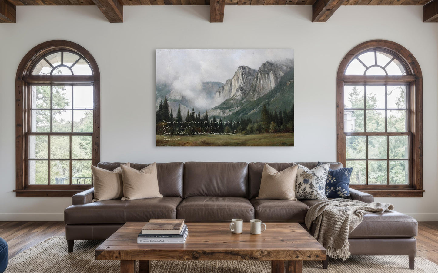 a cozy living room with a large window overlooking a picturesque mountain landscape. The room is furnished with a brown leather sofa, a wooden coffee table, and a bookshelf. A large painting of a mountain landscape hangs on the wall above the sofa, adding a touch of nature and serenity to the space.