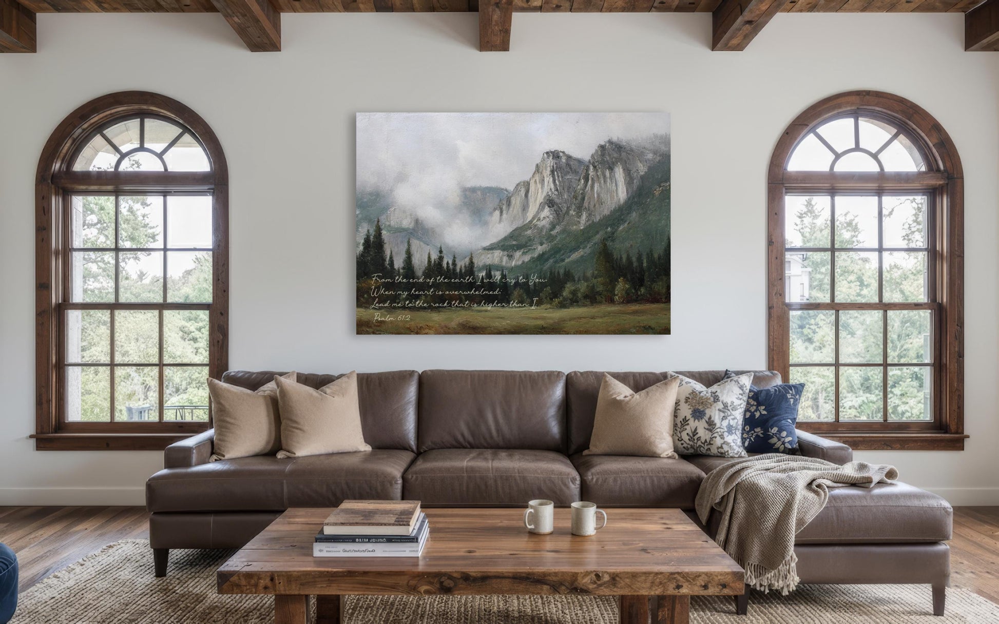 a cozy living room with a large window overlooking a picturesque mountain landscape. The room is furnished with a brown leather sofa, a wooden coffee table, and a bookshelf. A large painting of a mountain landscape hangs on the wall above the sofa, adding a touch of nature and serenity to the space.