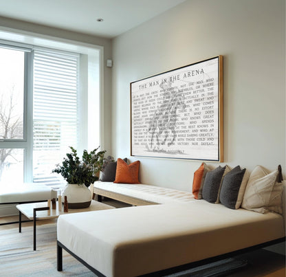 a modern living room with a large framed quote on the wall, a white sofa with pillows, and a potted plant.