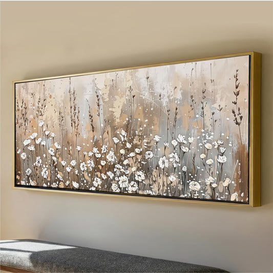 a large, framed painting of a field of white flowers on a wall.
