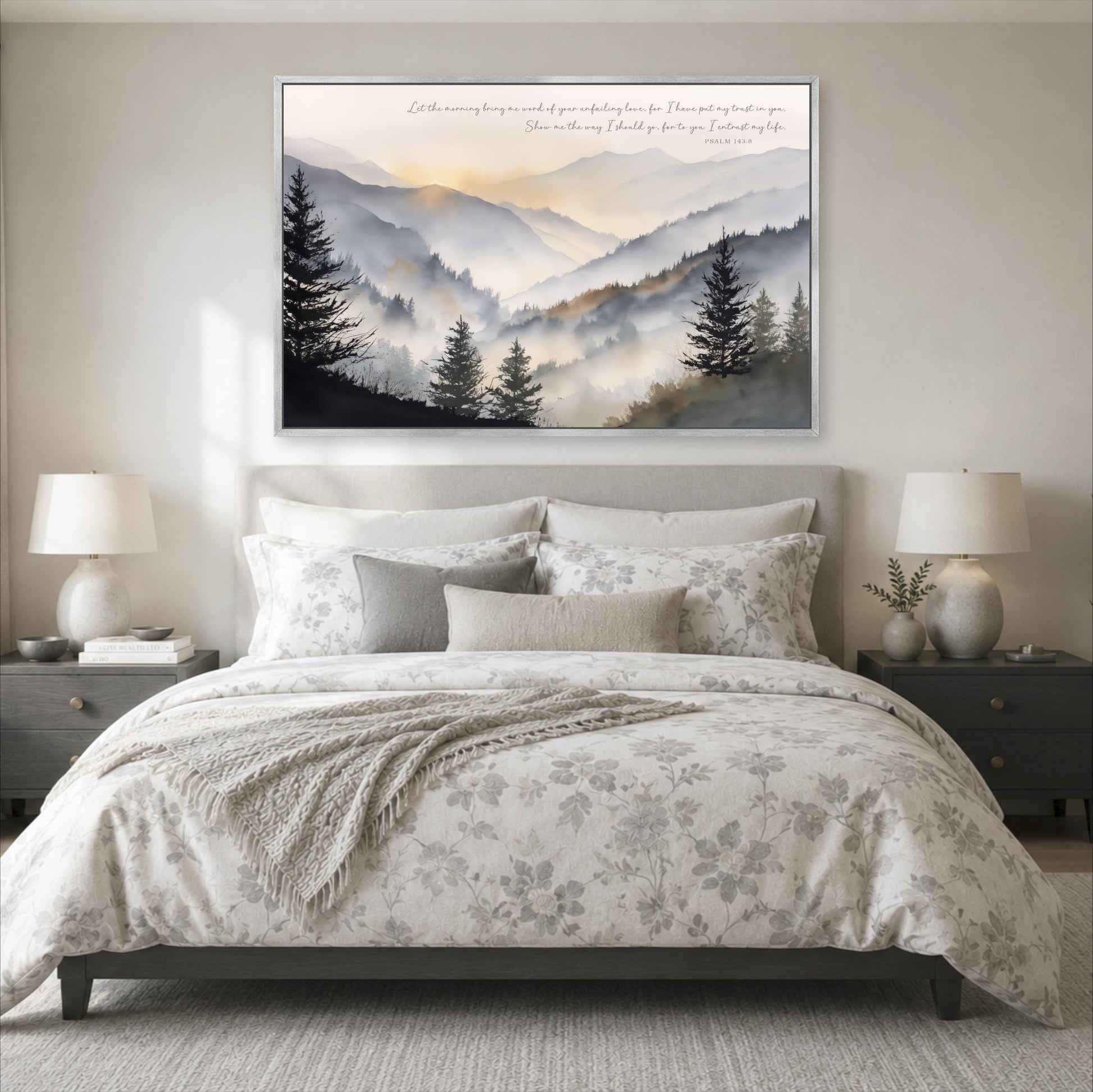 a serene bedroom scene with a large bed, a nightstand on each side, and a framed landscape painting above the bed. The painting depicts a mountain landscape with trees and a hazy, golden sky.