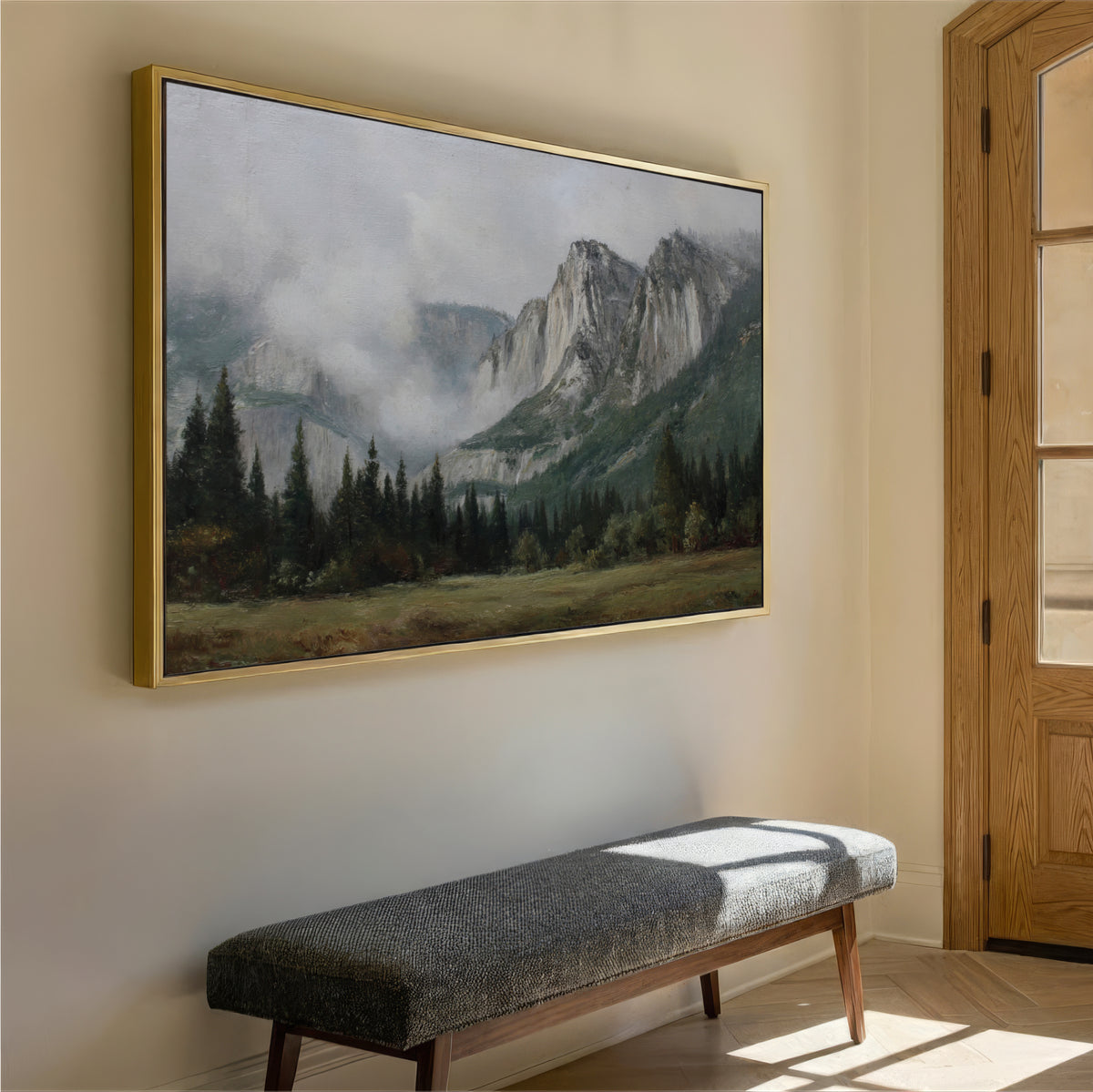 a large landscape painting hanging on a wall, depicting a mountainous scene with trees and a misty atmosphere. In the foreground, there is a gray bench positioned against the wall.