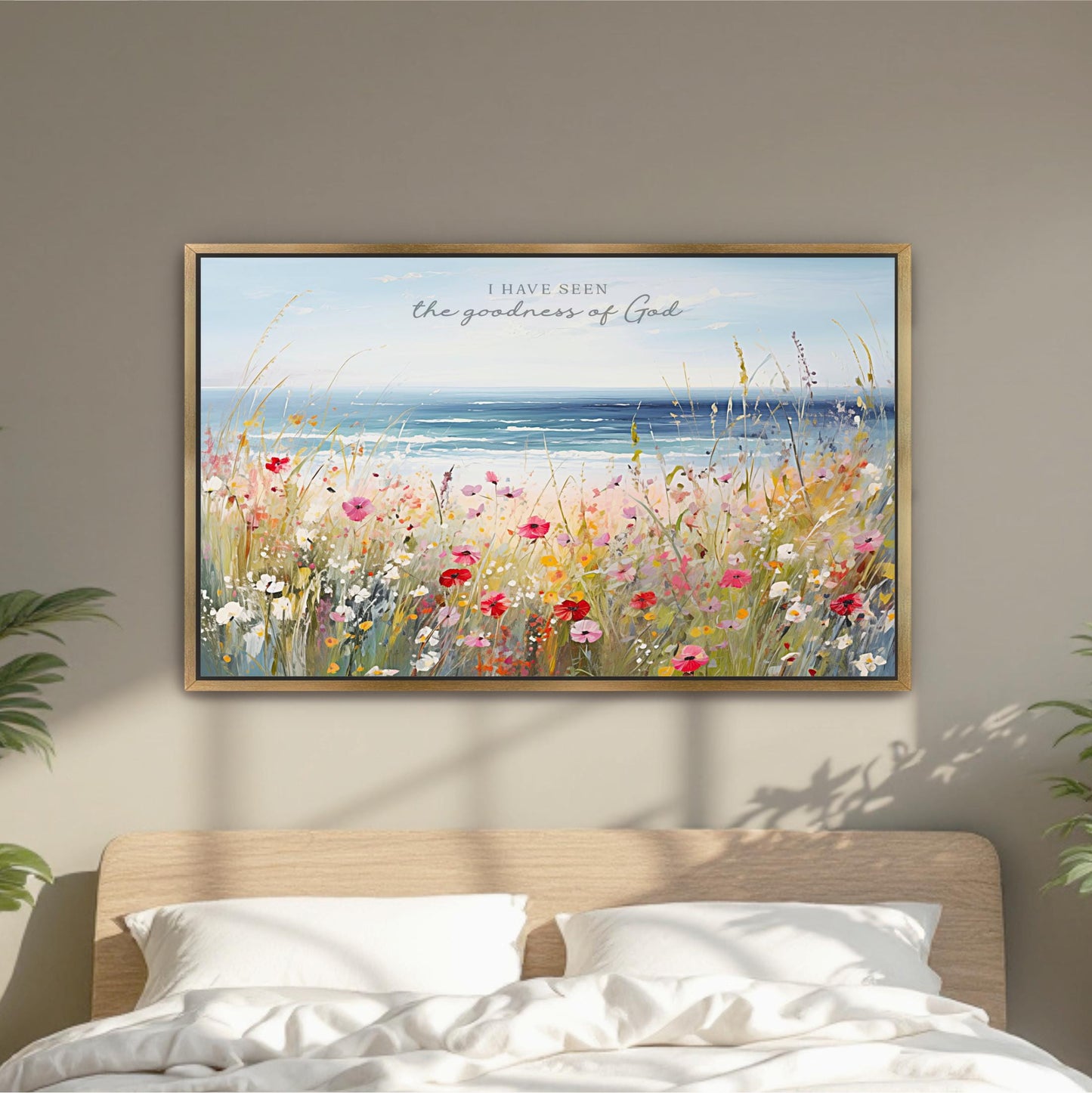 a framed painting of a field of colorful flowers, with a serene ocean view in the background.