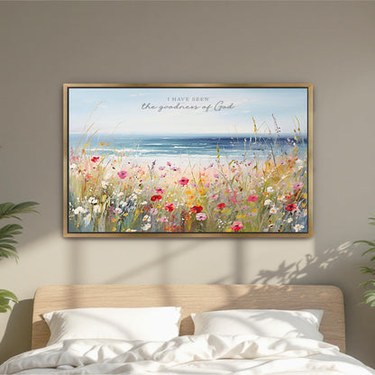 a framed painting of a field of colorful flowers, with a serene ocean view in the background.