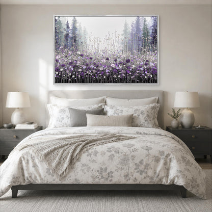 a serene bedroom scene with a large bed adorned with a floral comforter and pillows, flanked by two nightstands with lamps. Above the bed, a large framed painting of a field of purple flowers is displayed on the wall, creating a calming and peaceful atmosphere in the room.