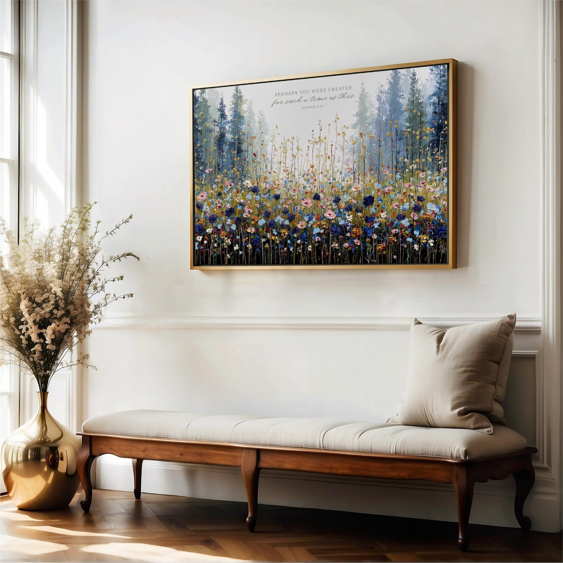 a large, framed painting of a field of flowers hanging on a white wall above a wooden bench.
