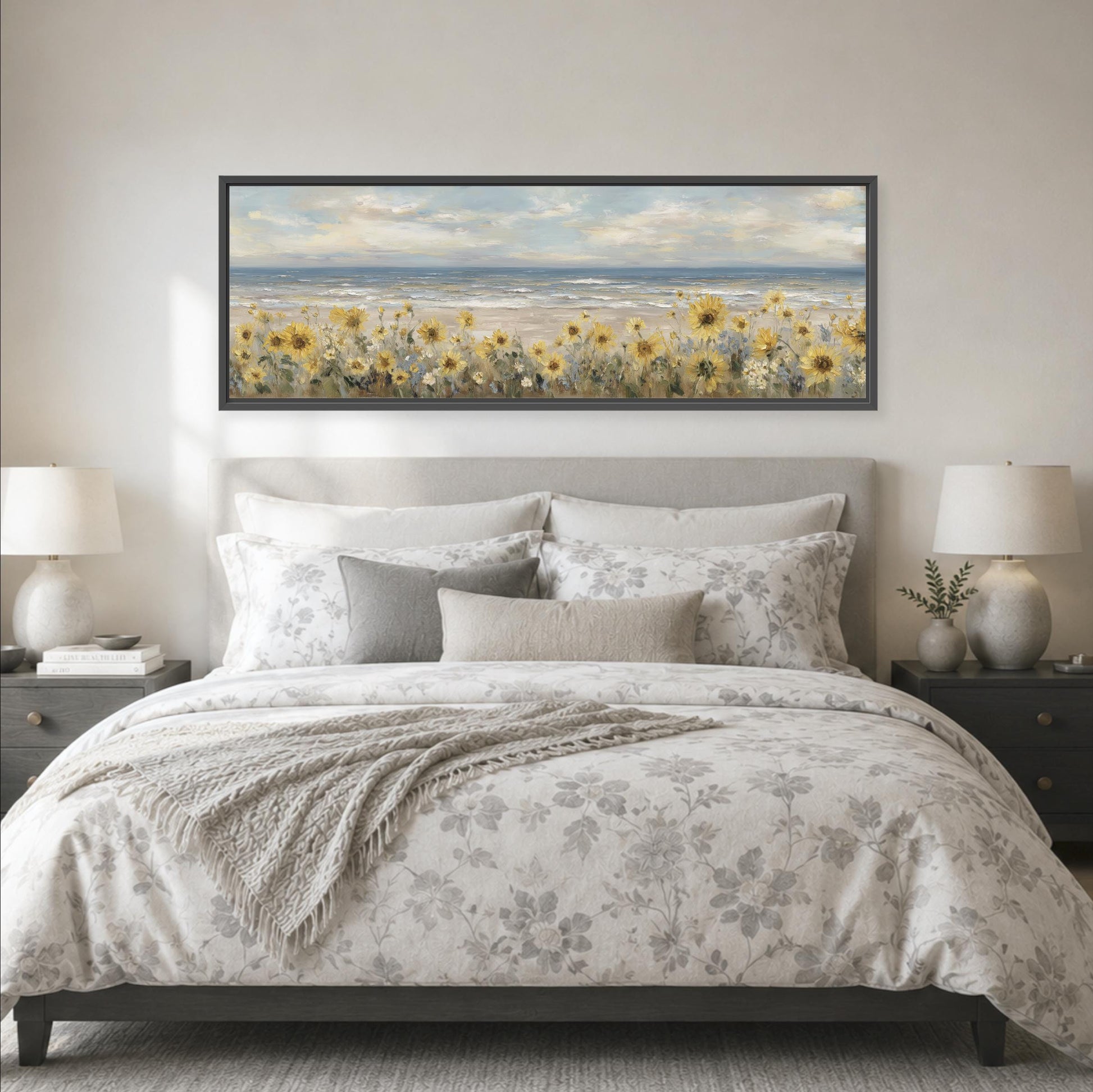 a large bed with a floral comforter and pillows, and a framed painting of a field of flowers above it. The painting is hanging on the wall above the bed.