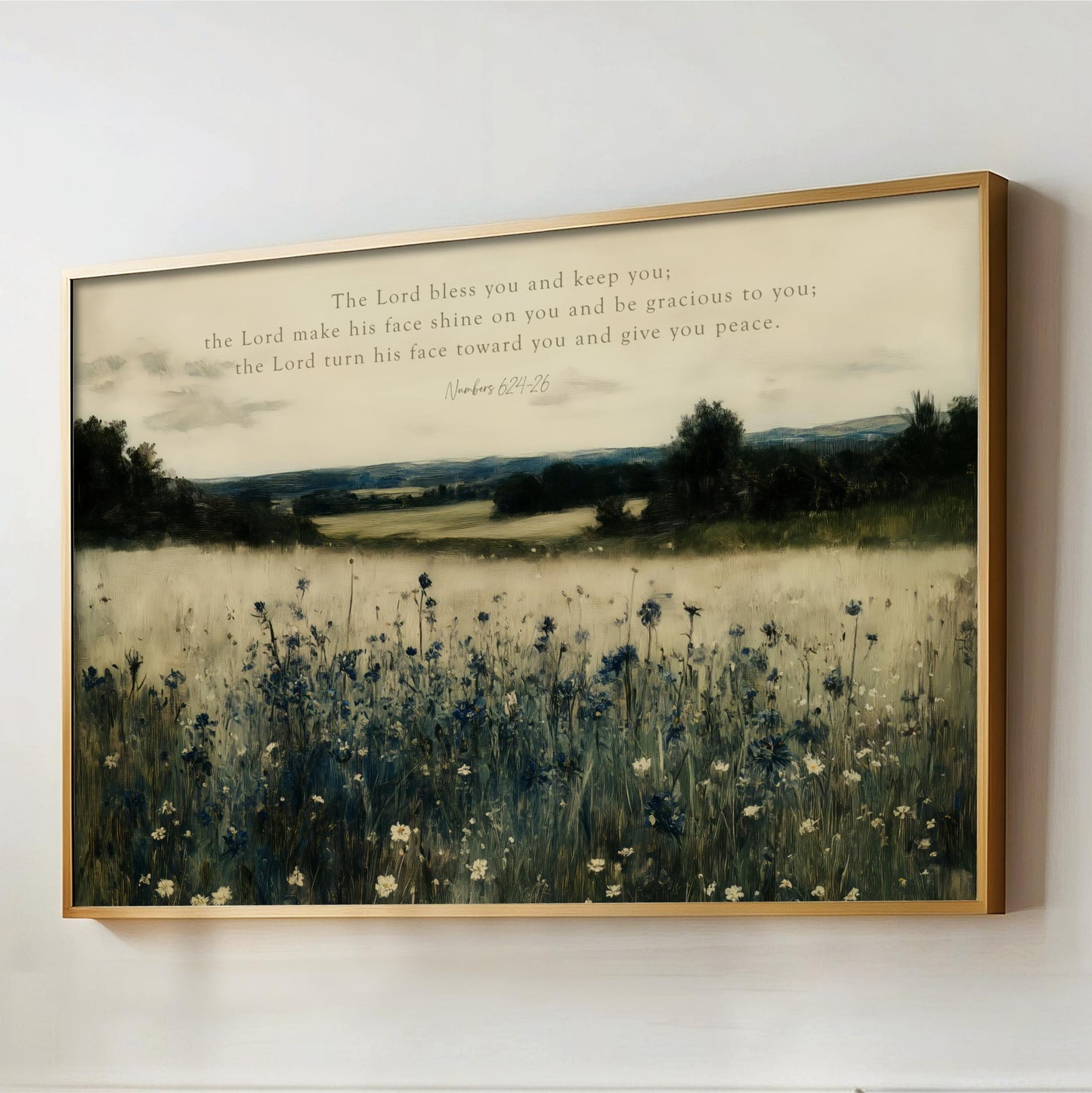 The image is a framed painting depicting a serene landscape with a field of tall grass and wildflowers, set against a backdrop of trees and hills. The painting is framed in a gold frame and hangs on a wall.