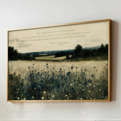 The image is a framed painting depicting a serene landscape with a field of tall grass and wildflowers, set against a backdrop of trees and hills. The painting is framed in a gold frame and hangs on a wall.