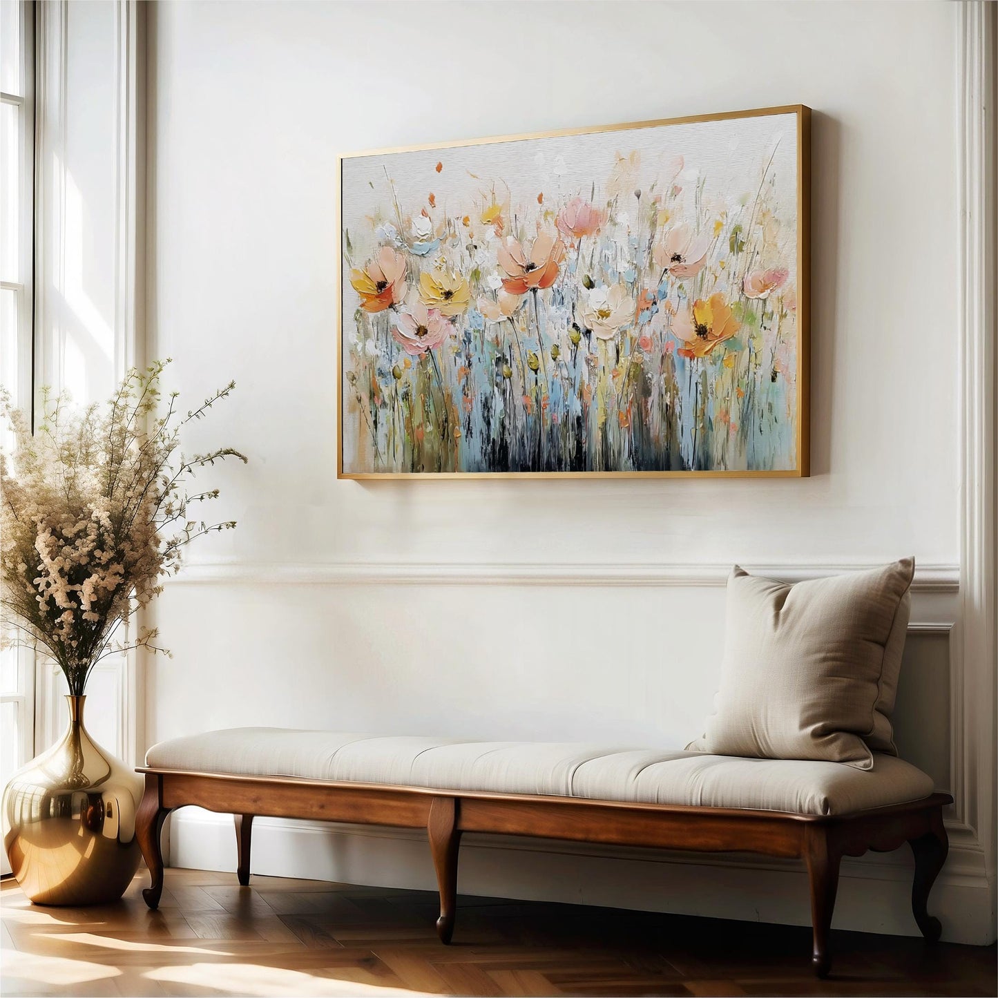 a large, colorful painting of flowers hanging on a white wall above a wooden bench with a beige cushion.