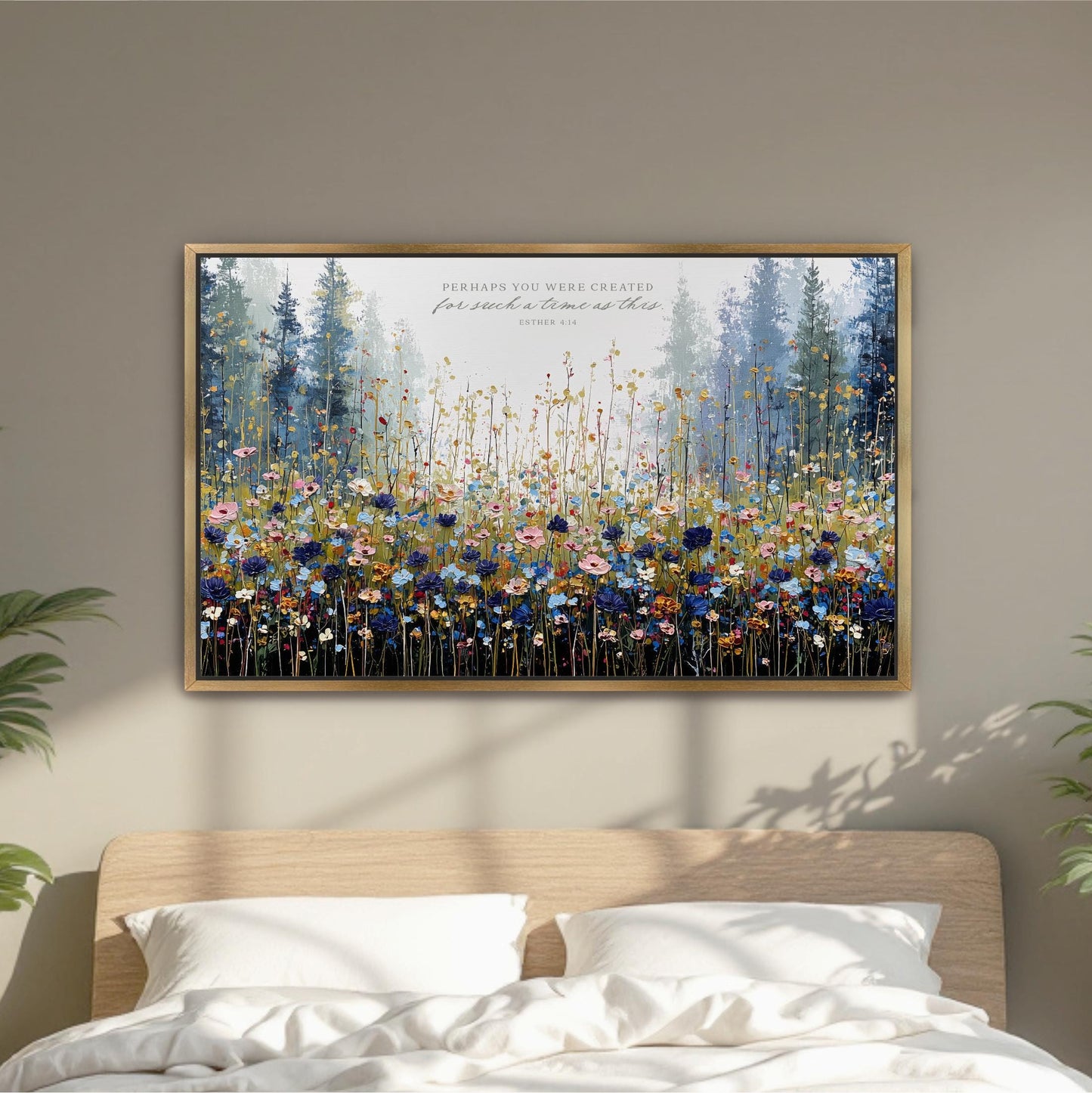 a large, framed painting of a field of flowers hanging on a wall above a bed.