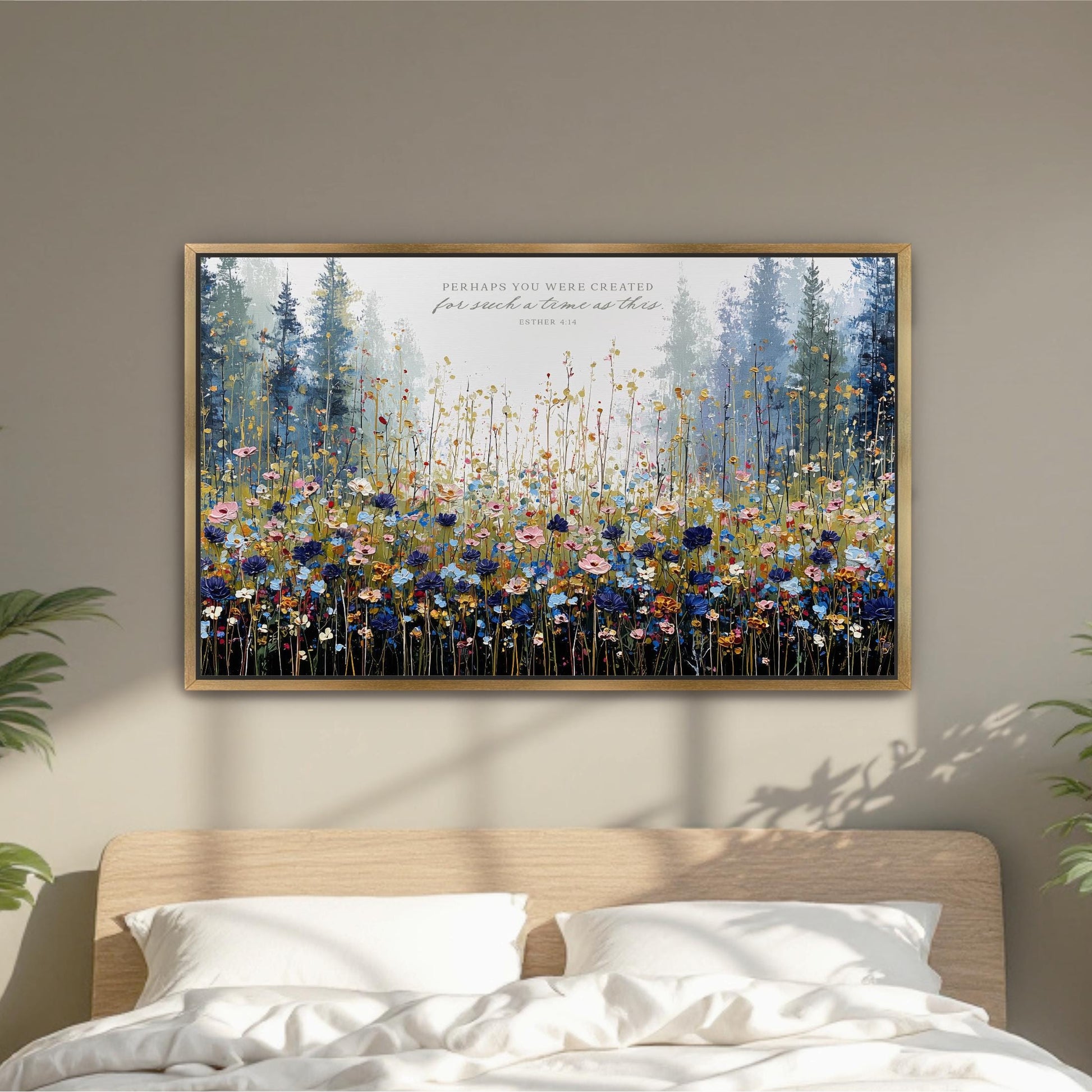 a large, framed painting of a field of flowers hanging on a wall above a bed.