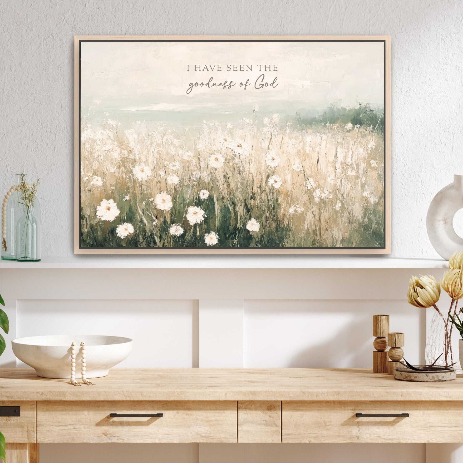 a table with a vase of flowers and a painting on the wall