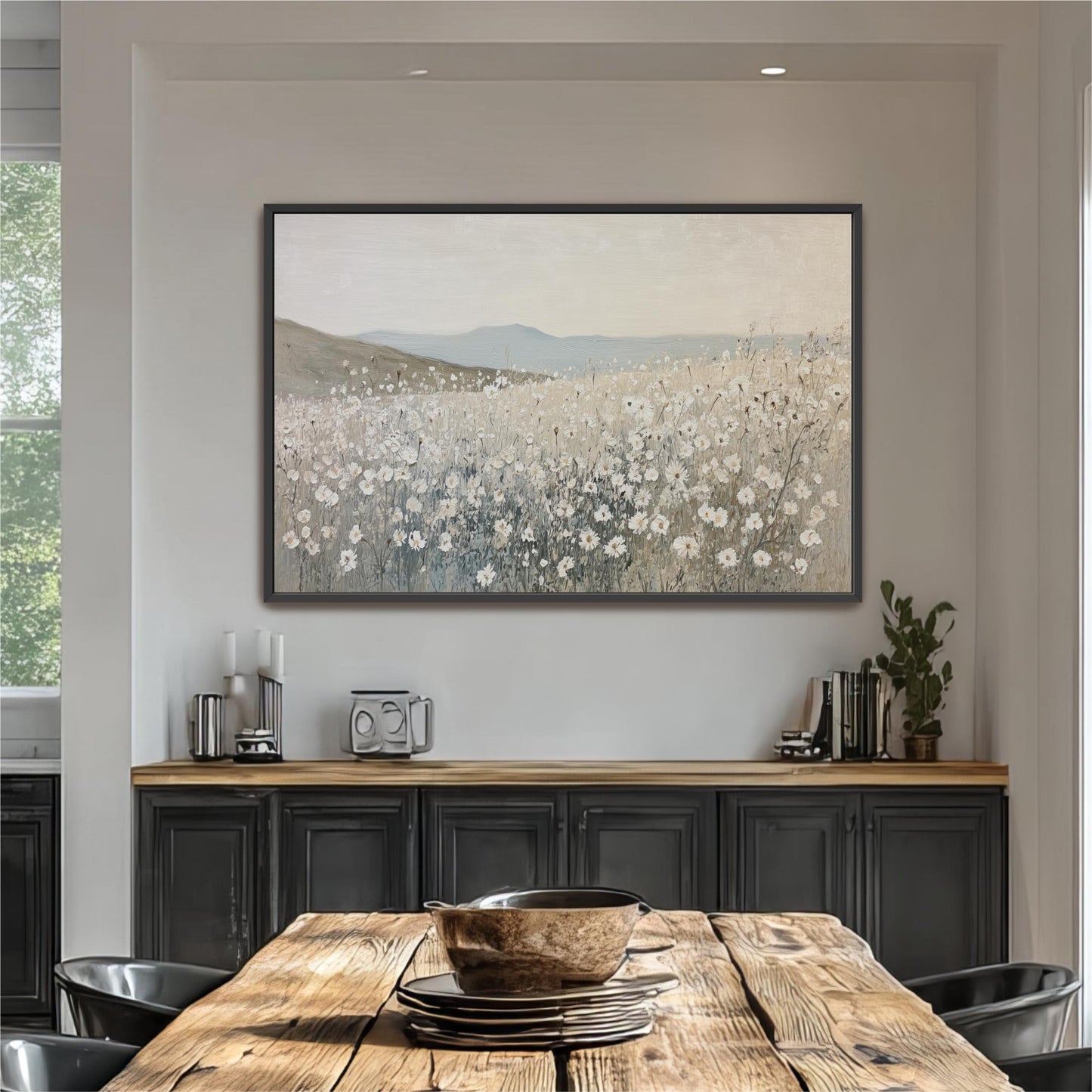 a large painting of a field with flowers hanging on the wall above a wooden dining table with chairs.