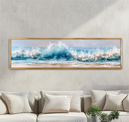 A large framed painting depicting a serene ocean scene with crashing waves is hanging on a wall above a beige sofa.