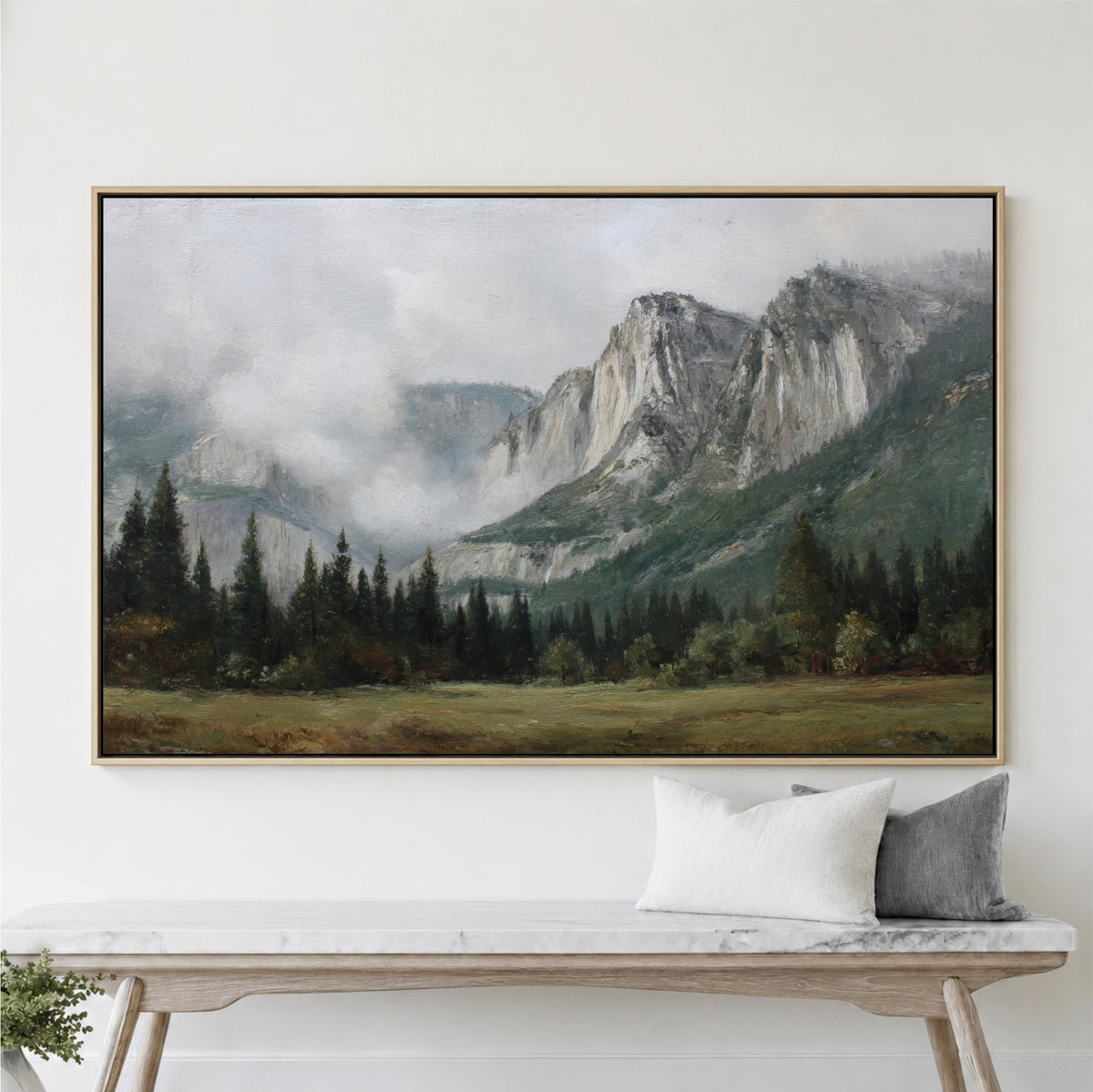 a large landscape painting hanging on a wall above a wooden bench with two pillows.