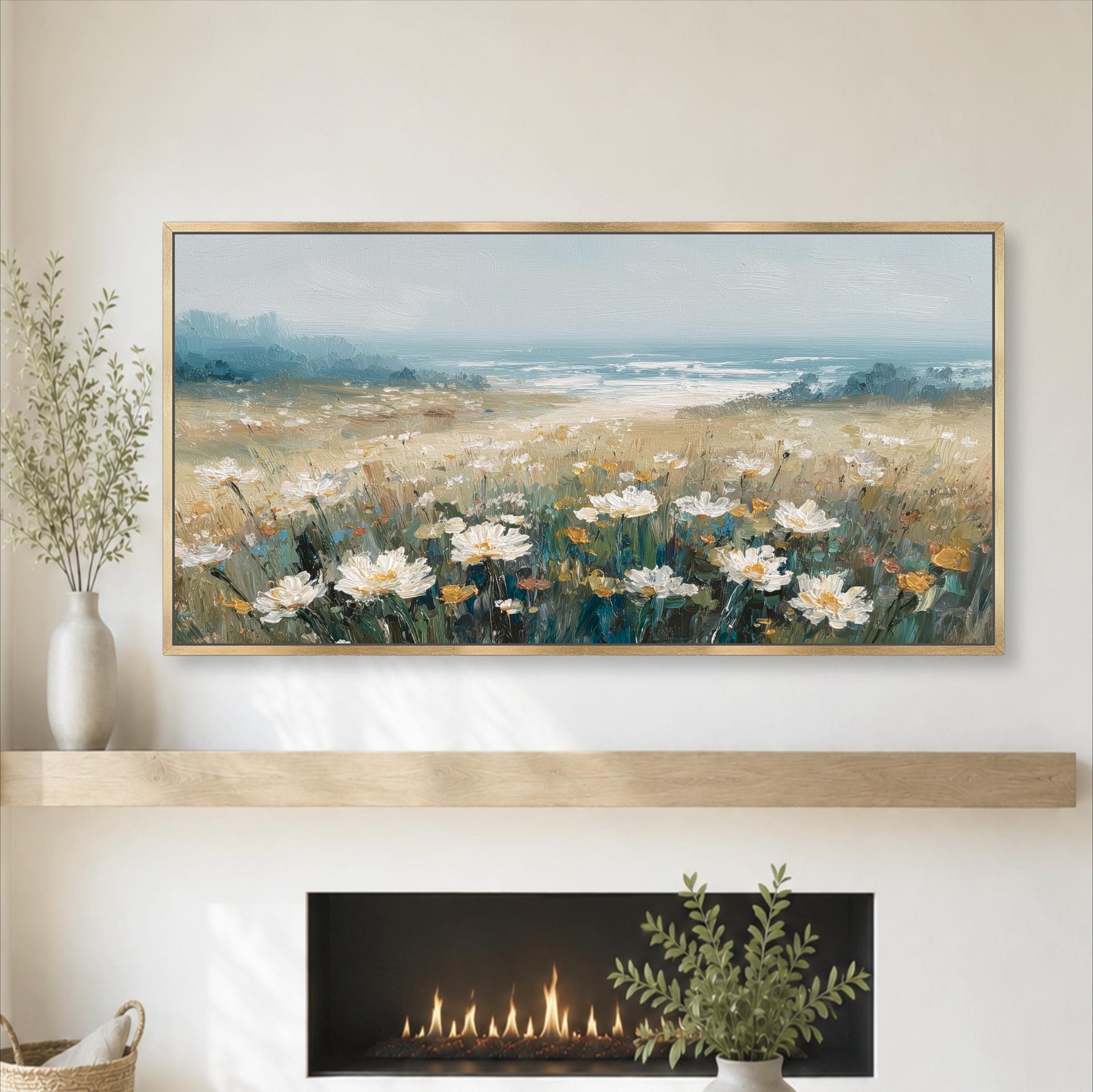 a large painting of a field of white flowers above a fireplace, with a vase of greenery on a shelf below the painting.