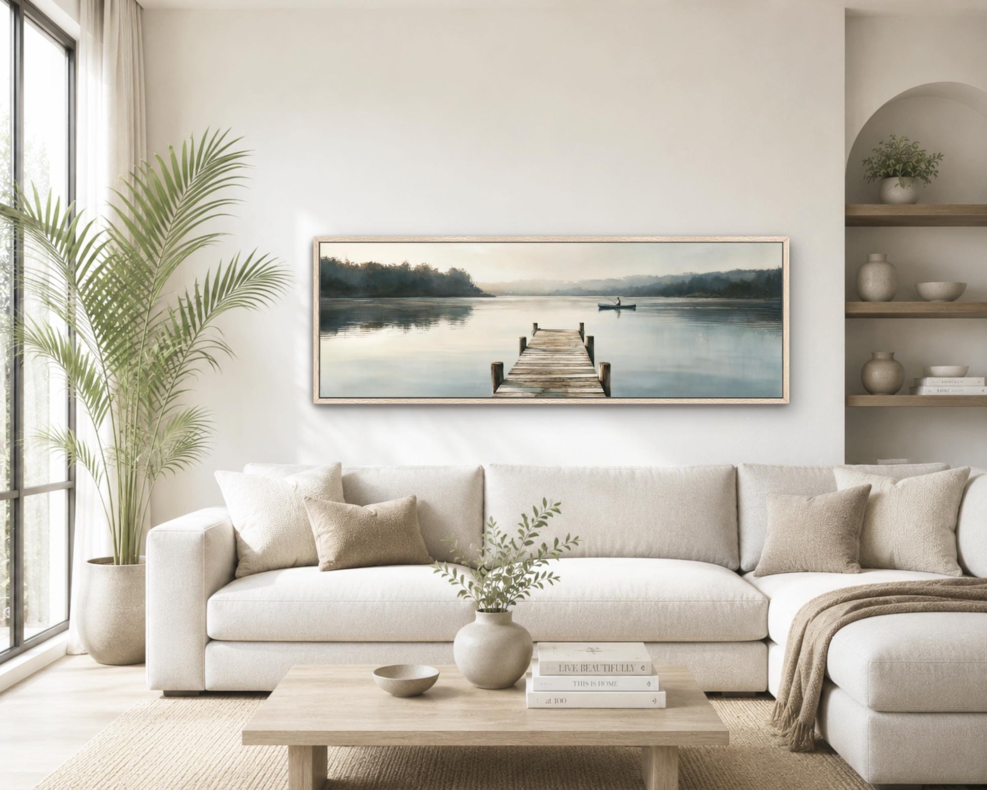 a serene living room with a large painting of a wooden dock and a boat on a calm lake hanging on the wall. The room is decorated with a white sofa, a coffee table, and a potted plant, creating a cozy and inviting atmosphere.