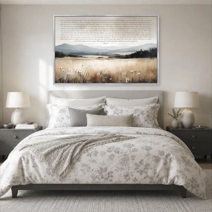 a large bed with a floral comforter and pillows, flanked by two nightstands with lamps. Above the bed is a framed painting depicting a serene landscape with a field of flowers and mountains in the background.