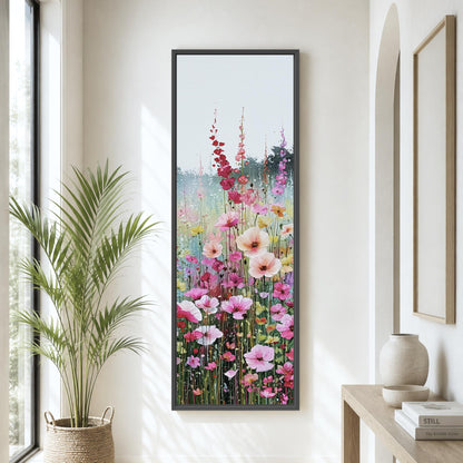 a large, colorful painting of a flower garden hanging on a wall in a room with a window and a plant.