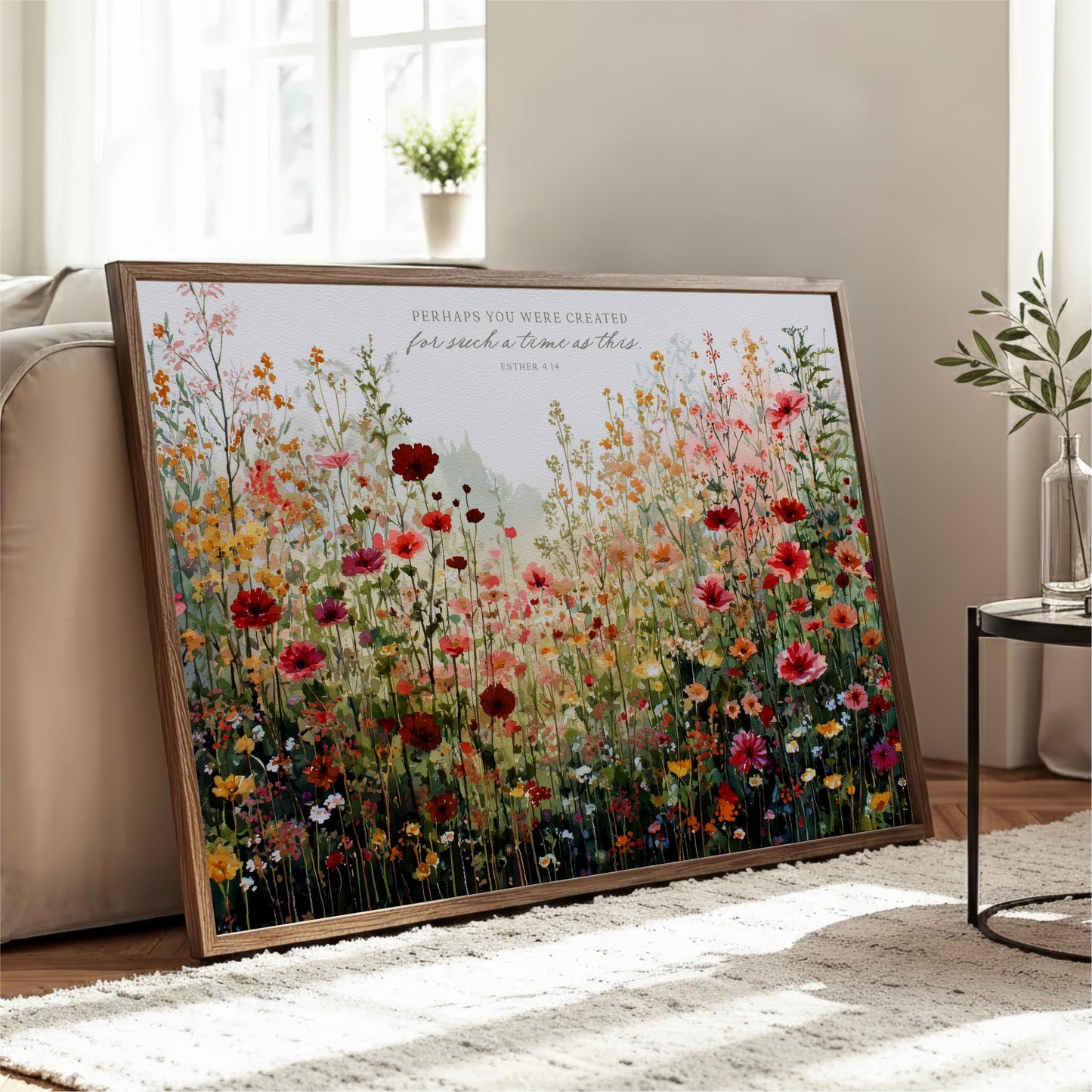 a large framed print of a vibrant, colorful floral scene, with various types of flowers and foliage. The print is displayed on a wooden stand in a living room setting, with a couch and a coffee table visible in the background.