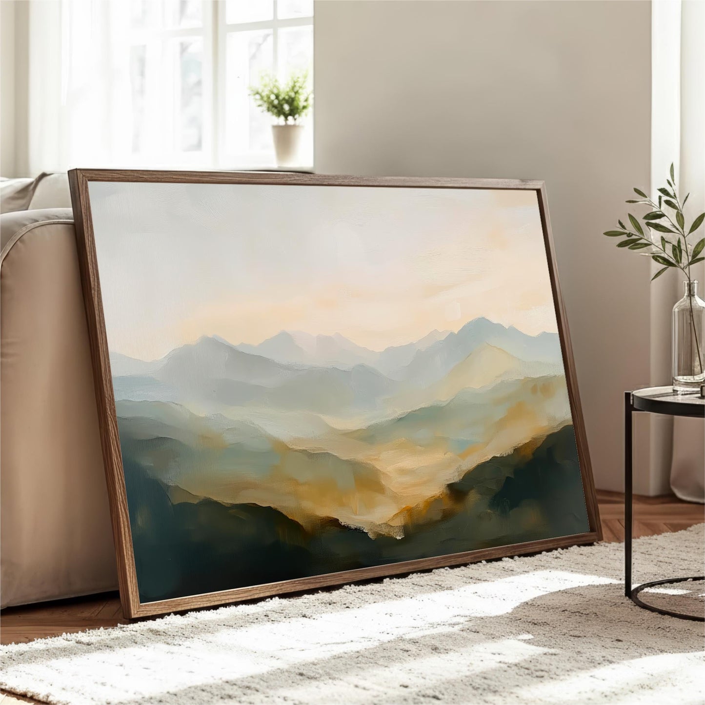 a large framed painting of a mountainous landscape, with a warm and serene color palette of green, orange, and blue. The painting is displayed on a wooden stand in a room with a window and a plant, creating a cozy and inviting atmosphere.