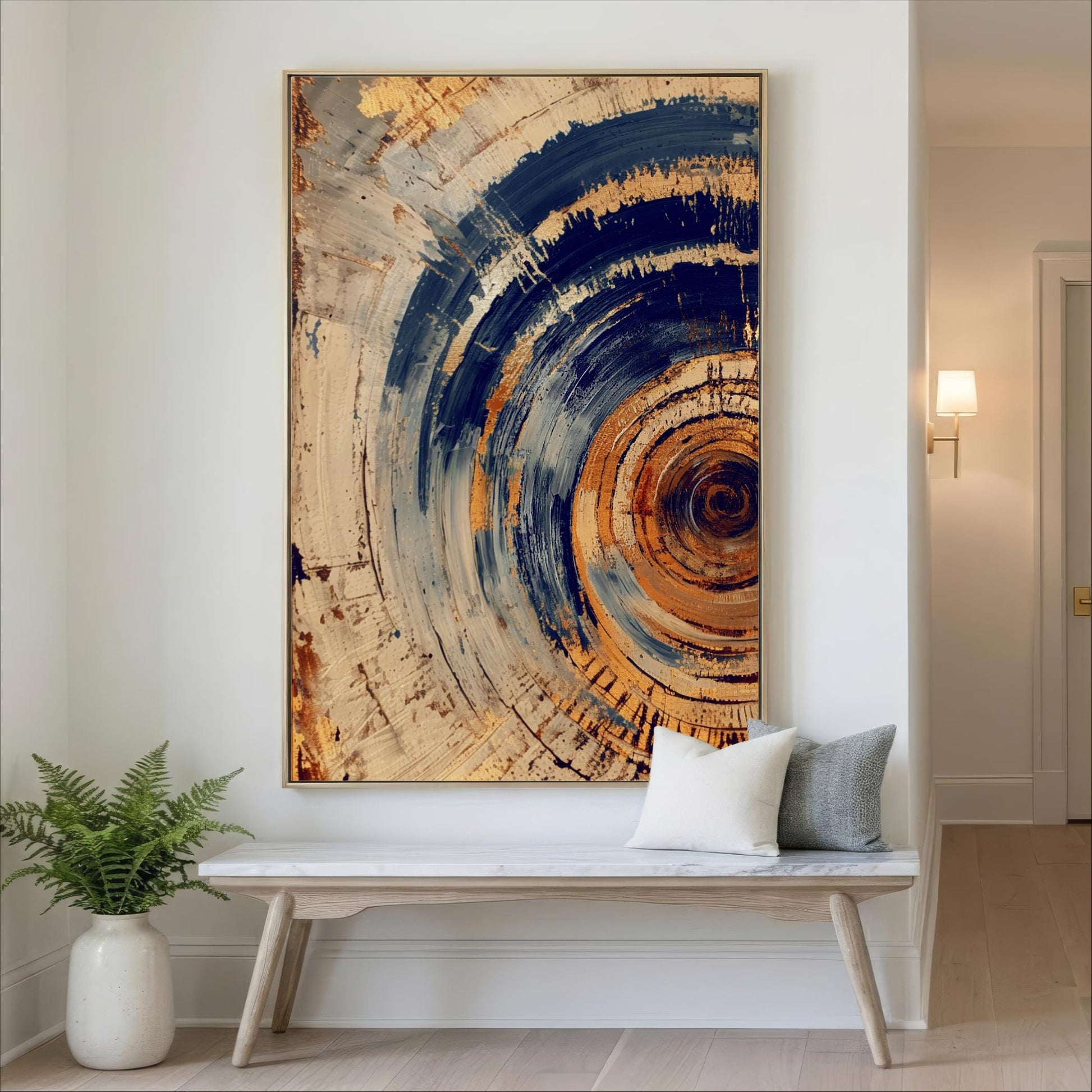 a large abstract painting hanging on a white wall above a wooden bench with two pillows.