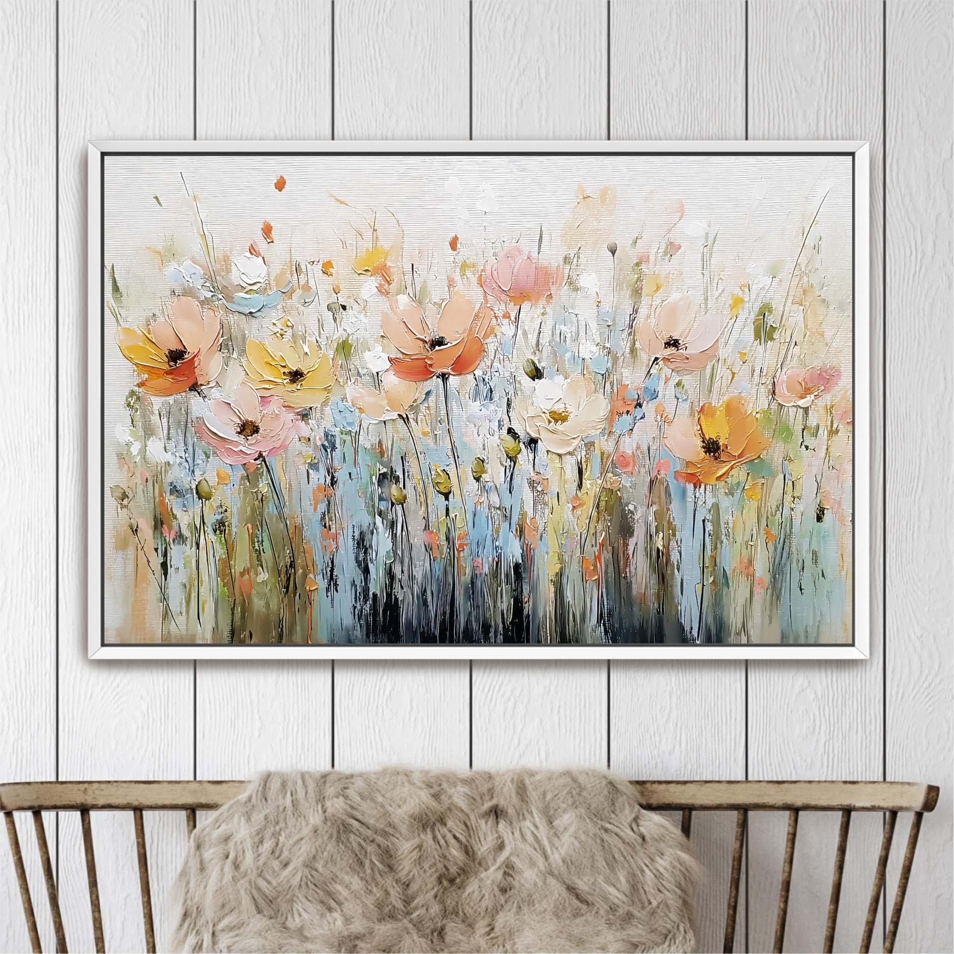 a large, colorful painting of flowers hanging on a wall above a wooden chair.