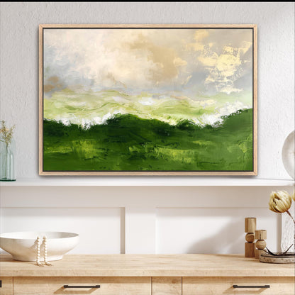 a large abstract painting of a green landscape with a cloudy sky above, hanging on a wall above a wooden shelf.