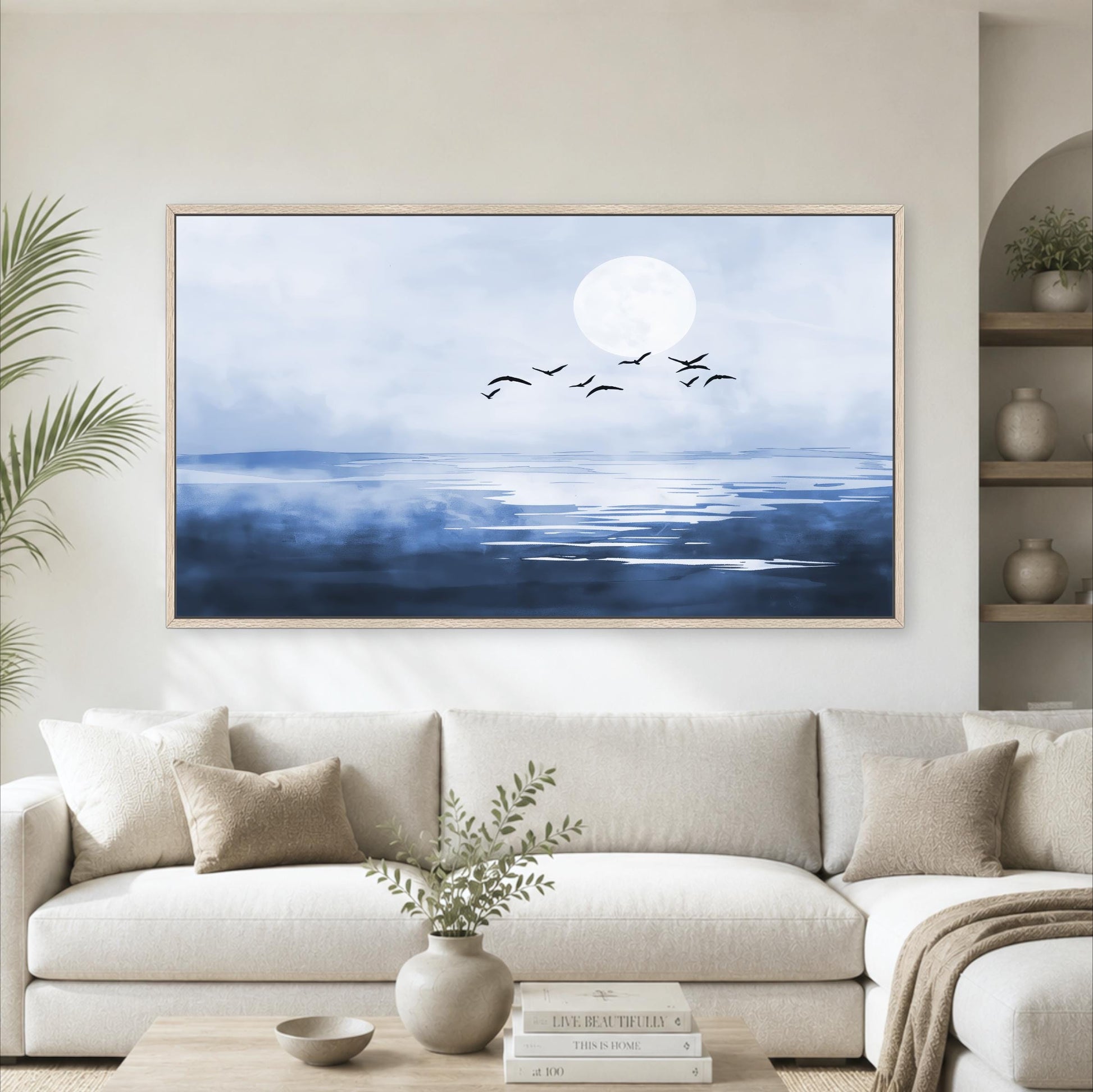 a large framed painting of a serene ocean scene with a full moon and a flock of birds flying over the water.