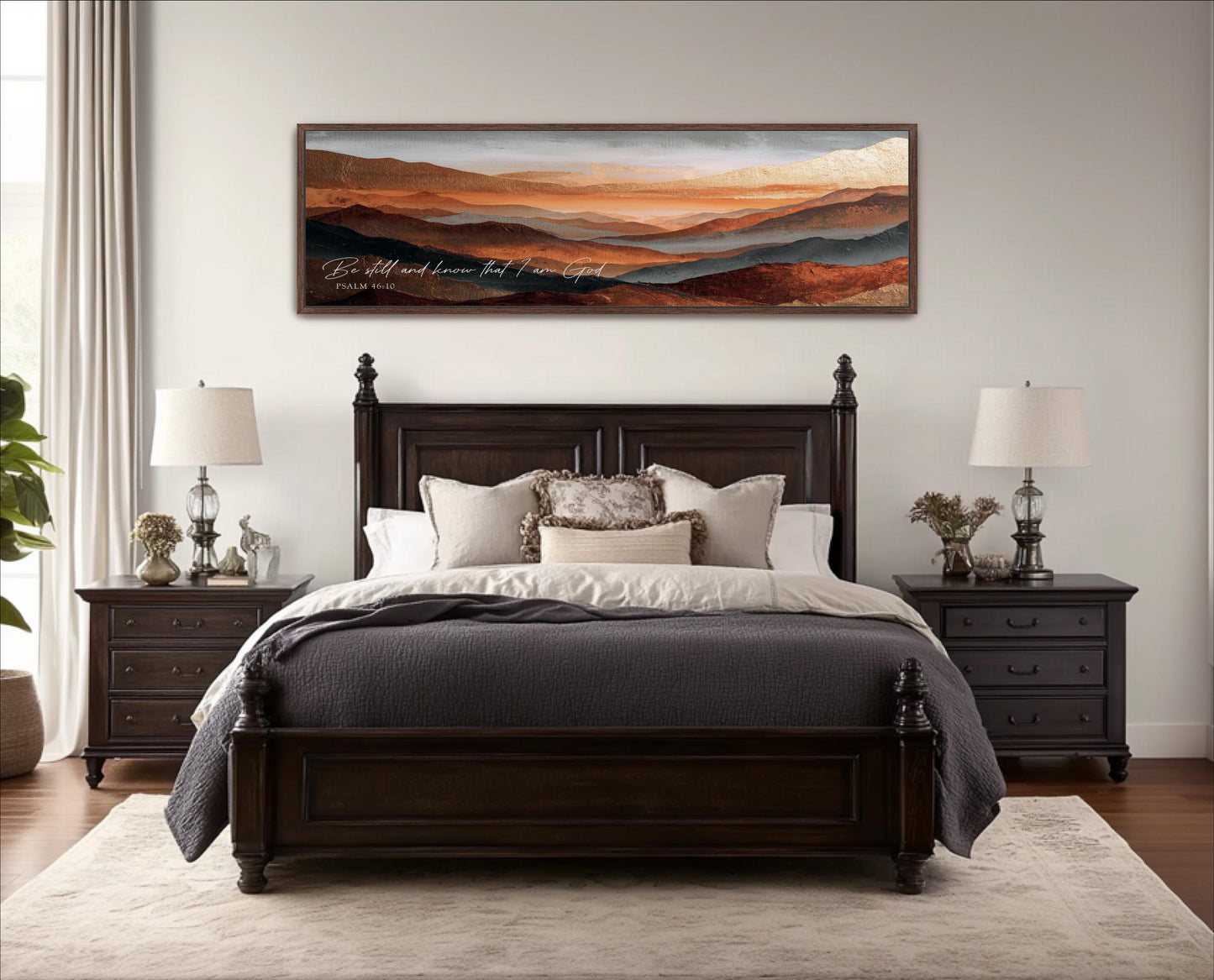 a large wooden bed with a gray comforter and pillows, flanked by two nightstands with lamps. Above the bed is a large framed landscape painting depicting a mountainous scene with a warm, orange and red color palette.