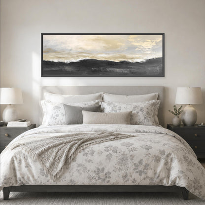 a serene bedroom scene with a large bed adorned with a floral comforter and pillows, flanked by two nightstands with lamps. Above the bed, a large framed landscape painting hangs on the wall, adding an artistic touch to the room's decor.