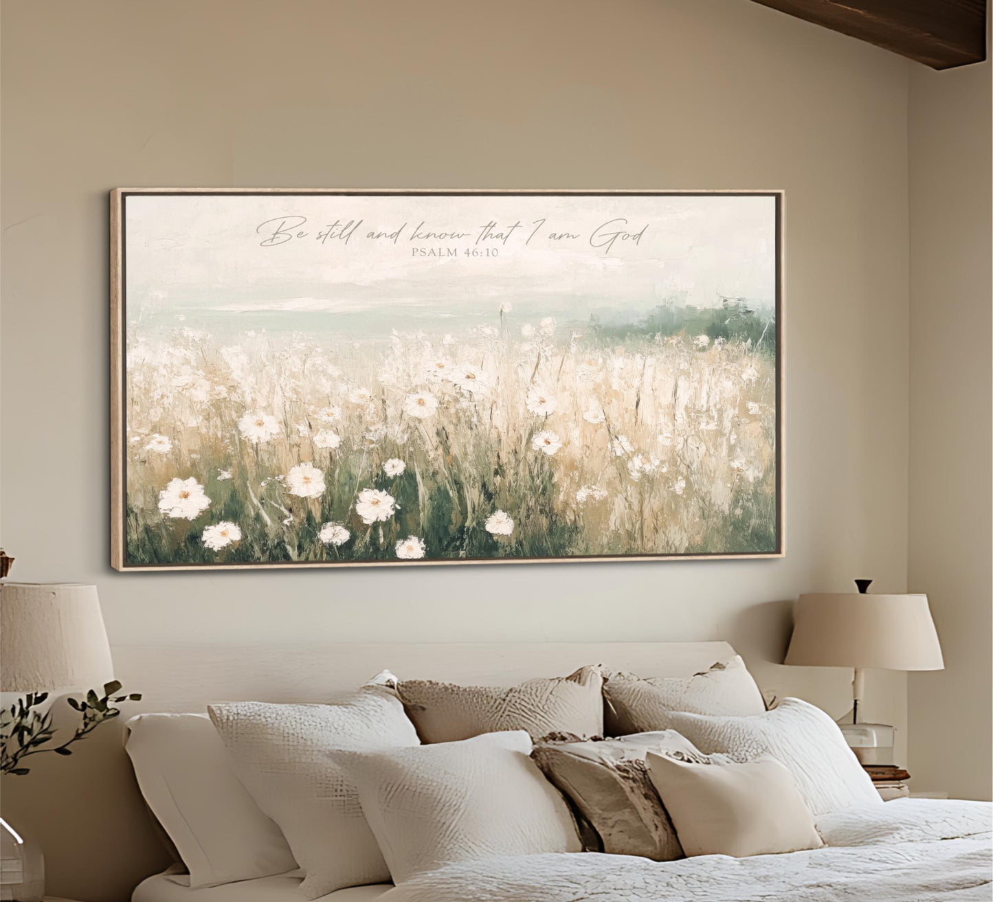 a large framed painting of a field of flowers hanging on a wall above a bed with white pillows and a beige headboard.