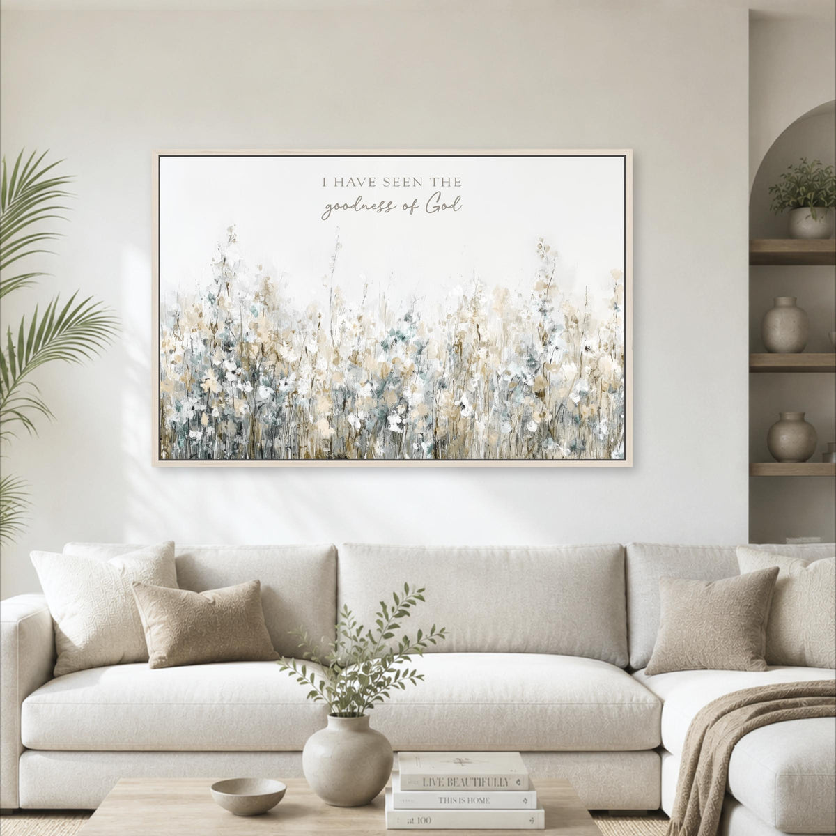 a large framed print of a field of flowers hanging on a wall above a white sofa in a living room.