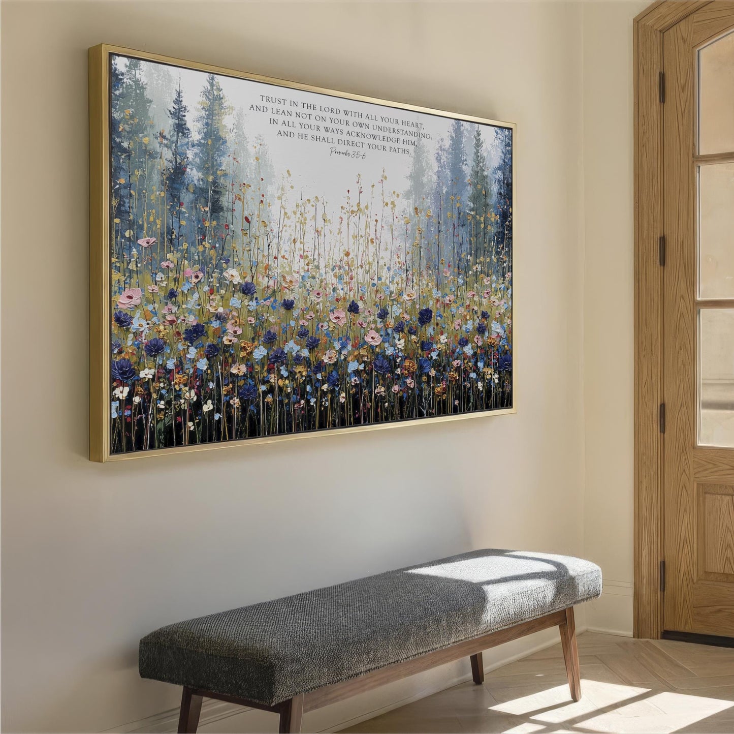 a large framed painting of a field of flowers hanging on a wall, with a wooden bench placed in front of it.