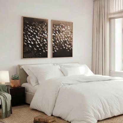 a serene and well-organized bedroom with a large bed, white bedding, and two framed artworks on the wall above it.