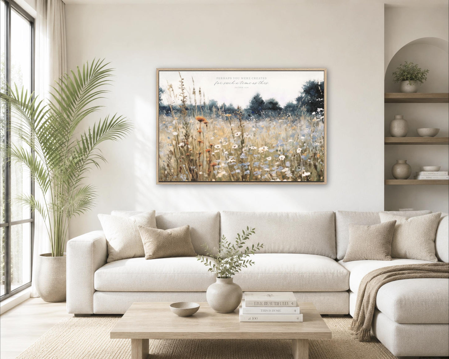 a serene living room with a large white sofa, a wooden coffee table, and a framed painting of a field of flowers hanging on the wall.