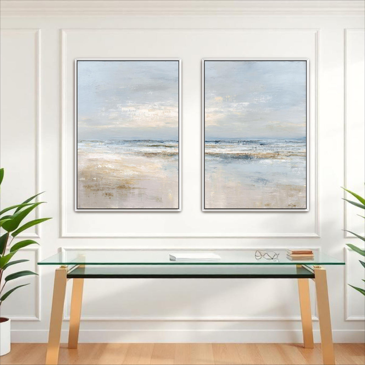 two large paintings of a serene landscape, hanging on a white wall above a glass desk with a white surface.