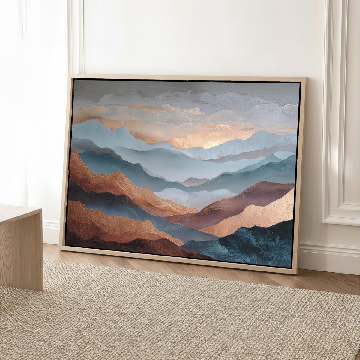 a large framed painting of mountains with a warm, golden-toned sky in the background.