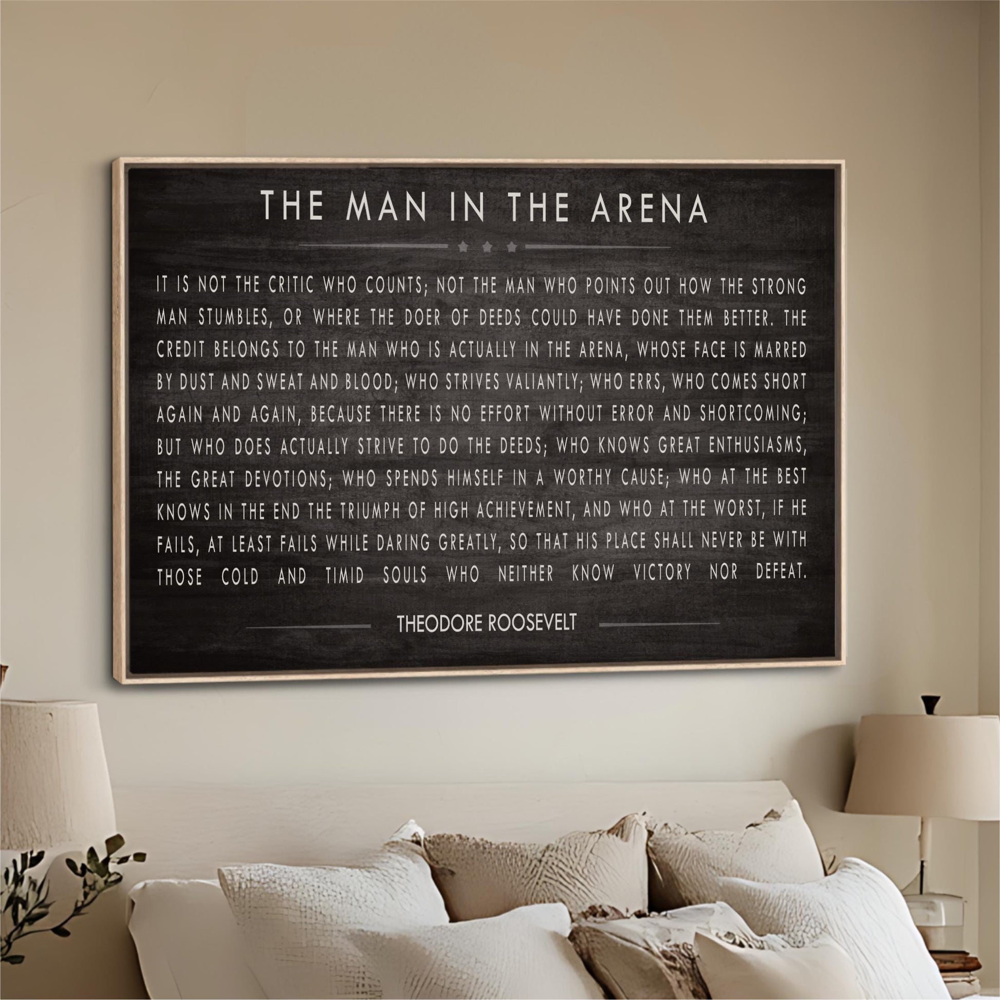 a framed quote by Theodore Roosevelt, which is displayed on a wall in a living room setting.