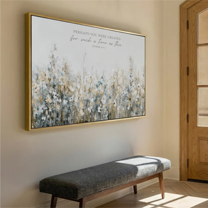 a large framed painting of a field of flowers hanging on a wall, with a gray bench placed in front of it.