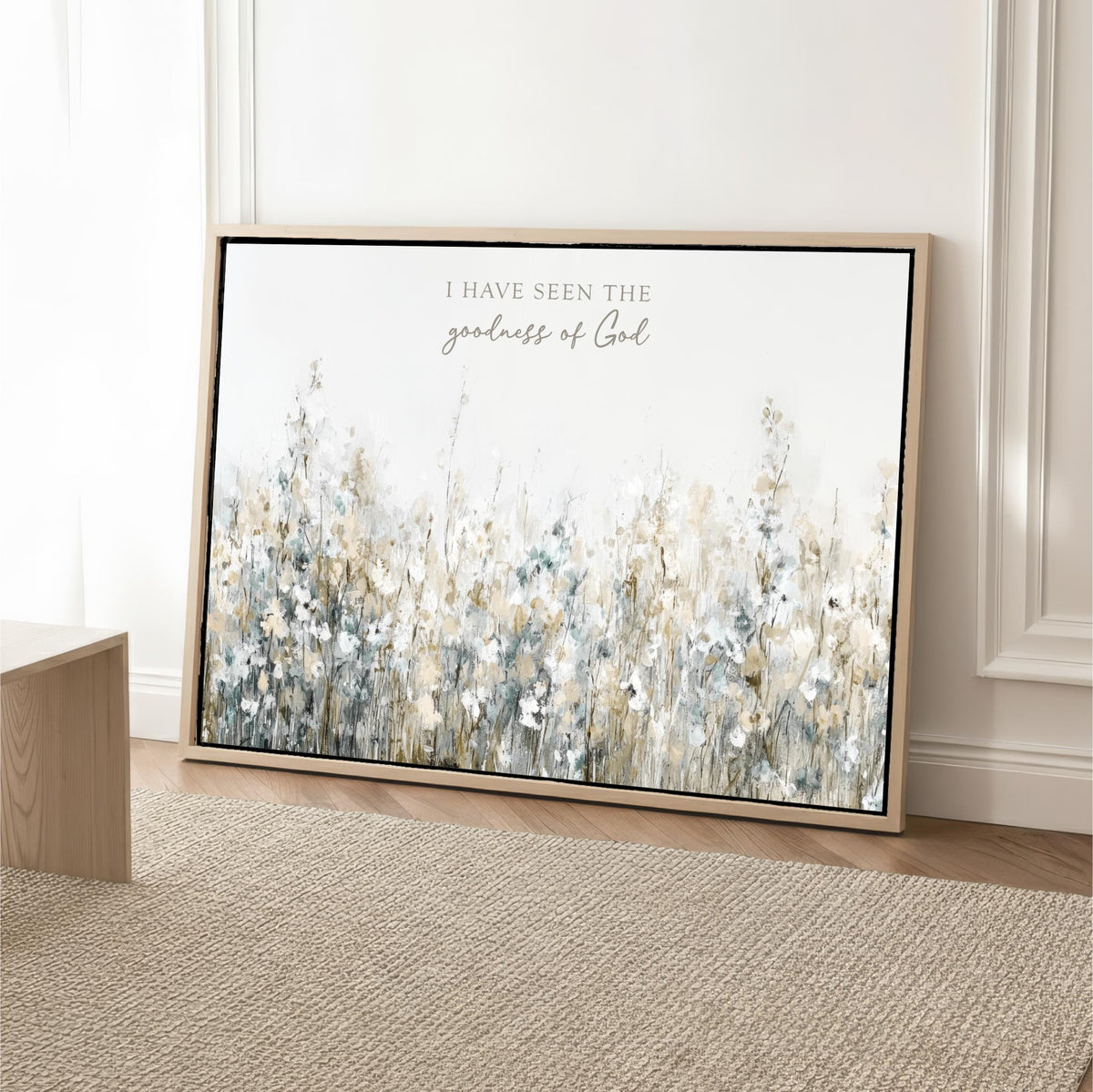 a large framed print of a floral landscape with the text "I have seen the goodness of God" written on it.