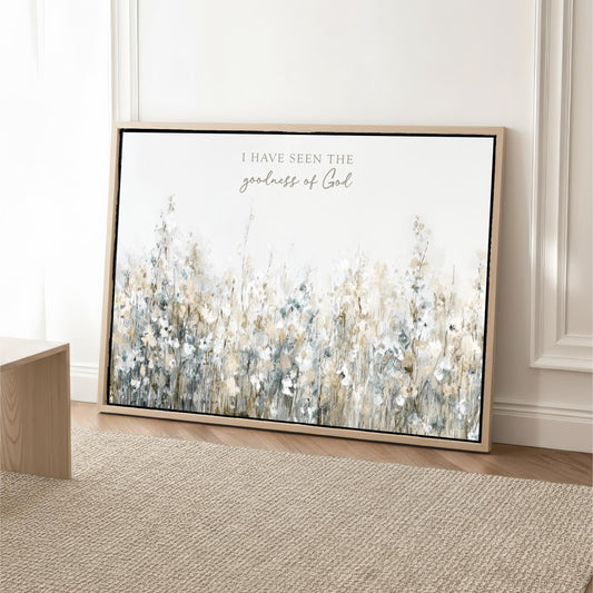 a large framed print of a floral landscape with the text "I have seen the goodness of God" written on it.