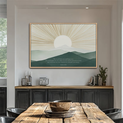 a large framed poster of a mountain landscape with a sunburst design, hanging on a wall above a wooden dining table with chairs.
