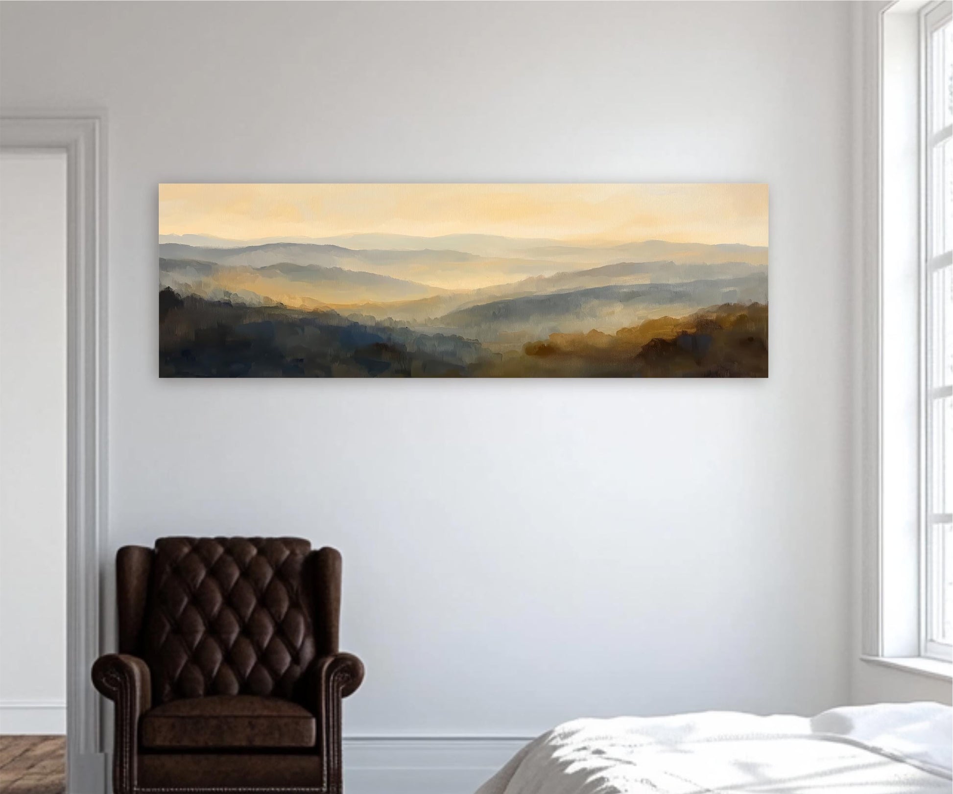 a large landscape painting hanging on a white wall, depicting a serene mountain range with a hazy, golden-yellow sky. In the foreground, there is a brown leather armchair, and a bed is visible in the background, suggesting a cozy bedroom setting.