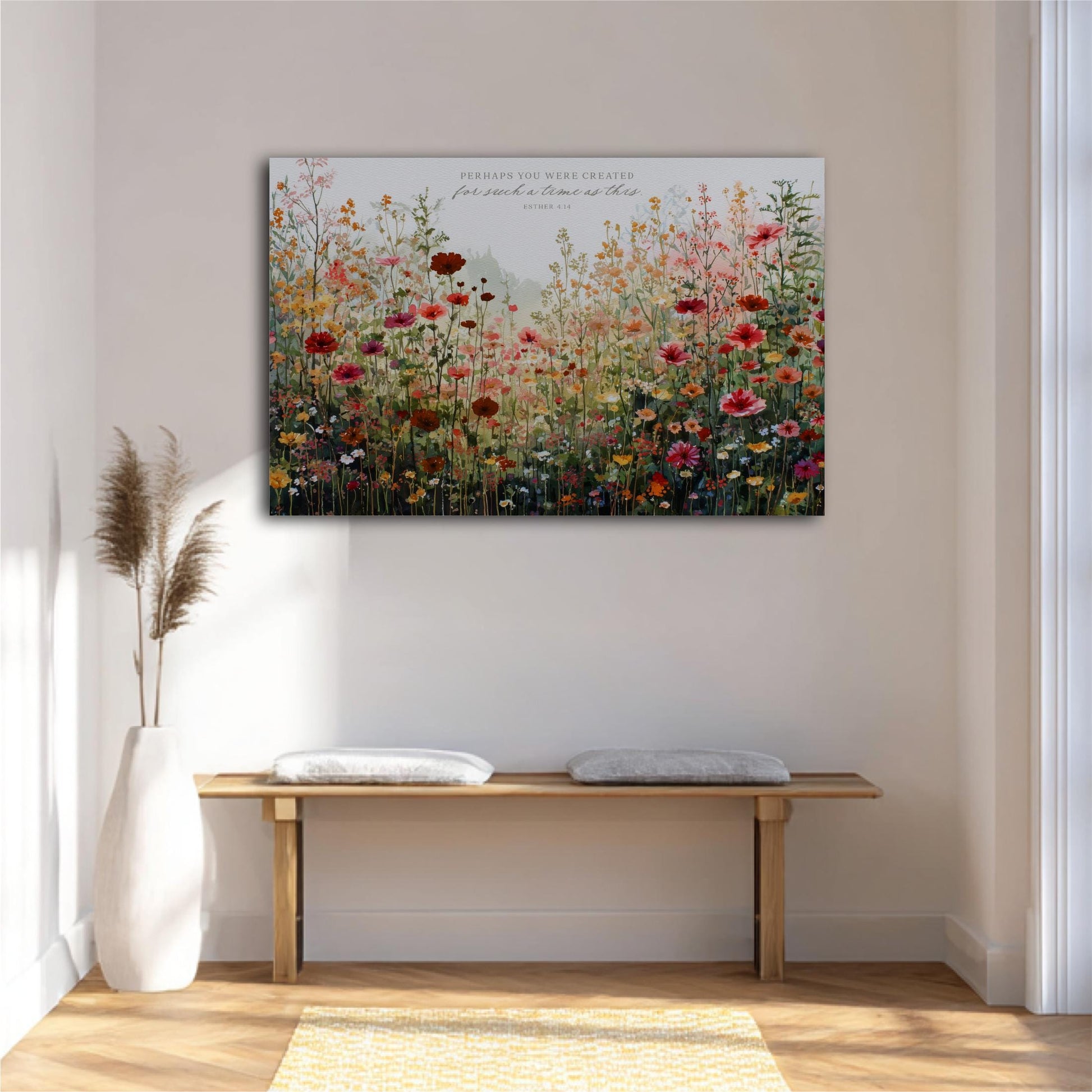 a large floral painting hanging on a white wall above a wooden bench with two white cushions.