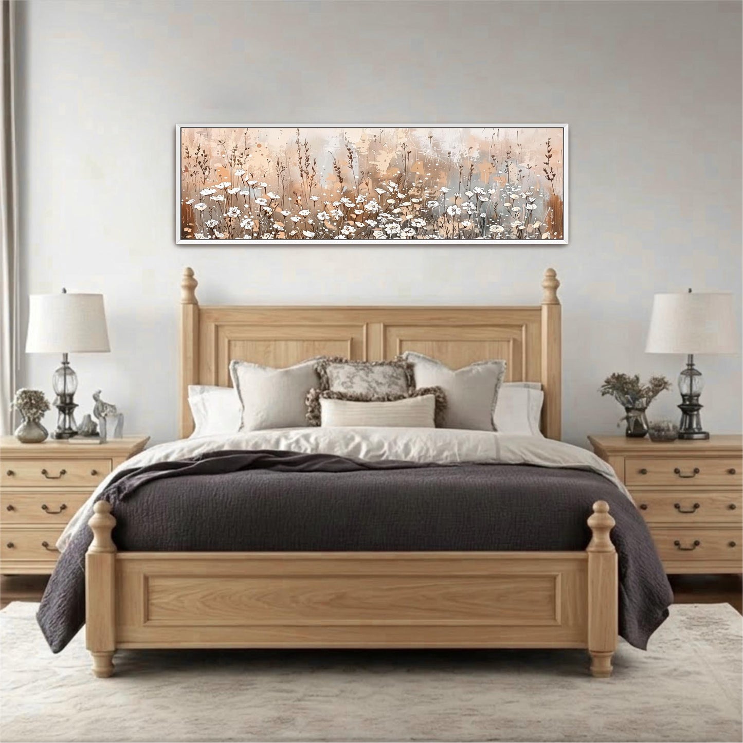 a large, wooden bed with a gray comforter and pillows, flanked by two nightstands with lamps. Above the bed is a framed painting depicting a field of flowers.