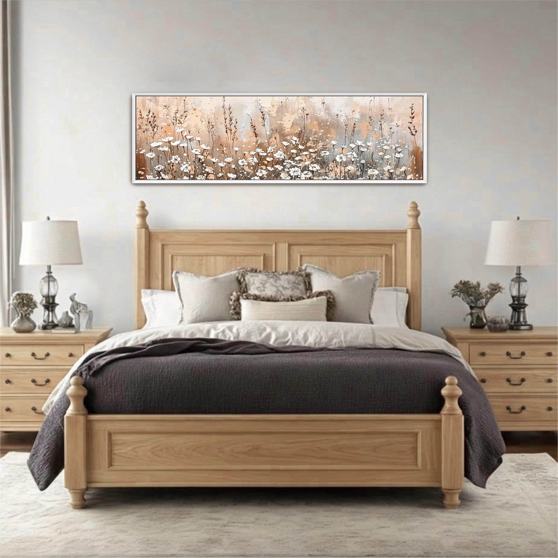a large, wooden bed with a gray comforter and pillows, flanked by two nightstands with lamps. Above the bed is a framed painting depicting a field of flowers.