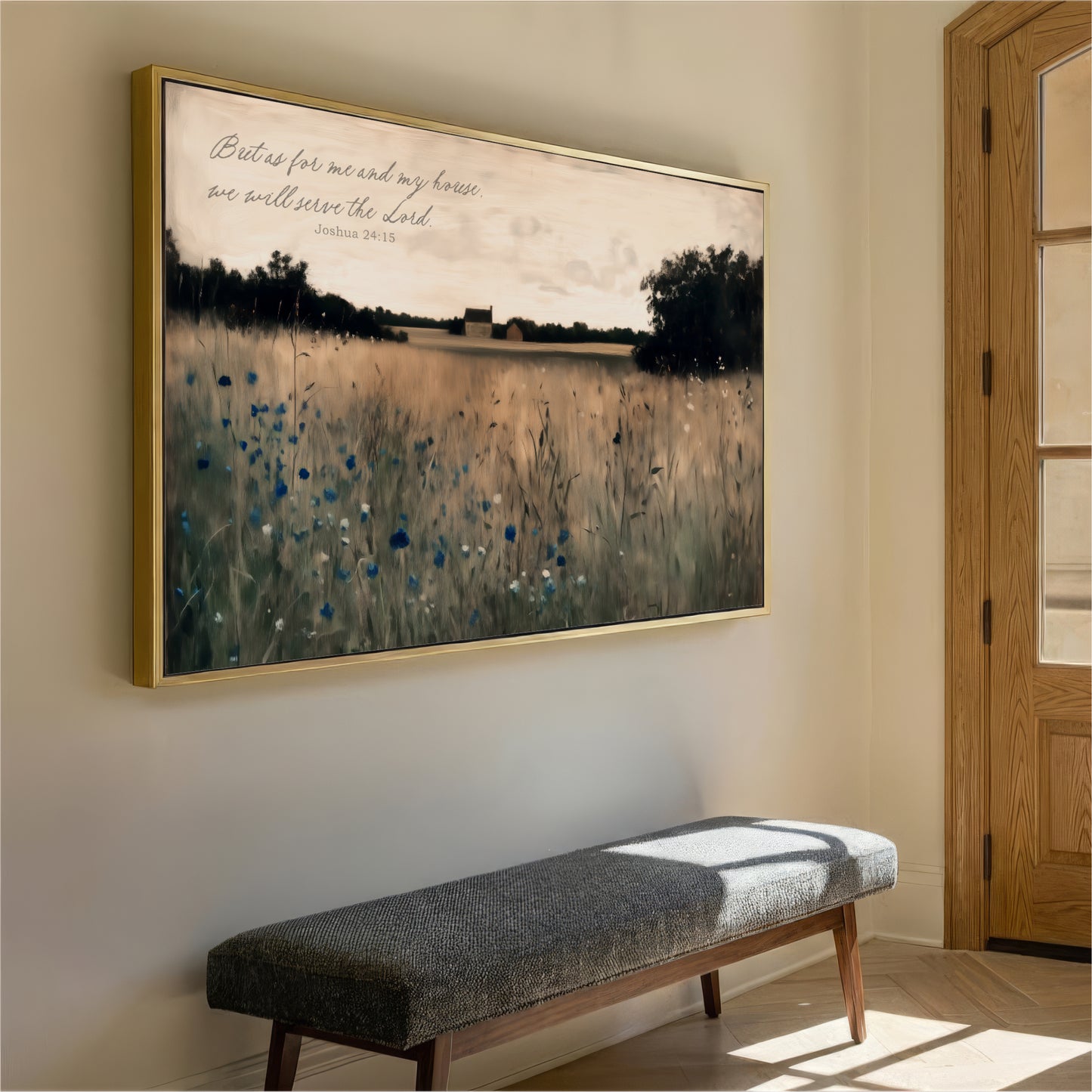 a large framed painting of a field with tall grass and blue flowers hanging on a wall. In front of the painting, there is a gray bench.