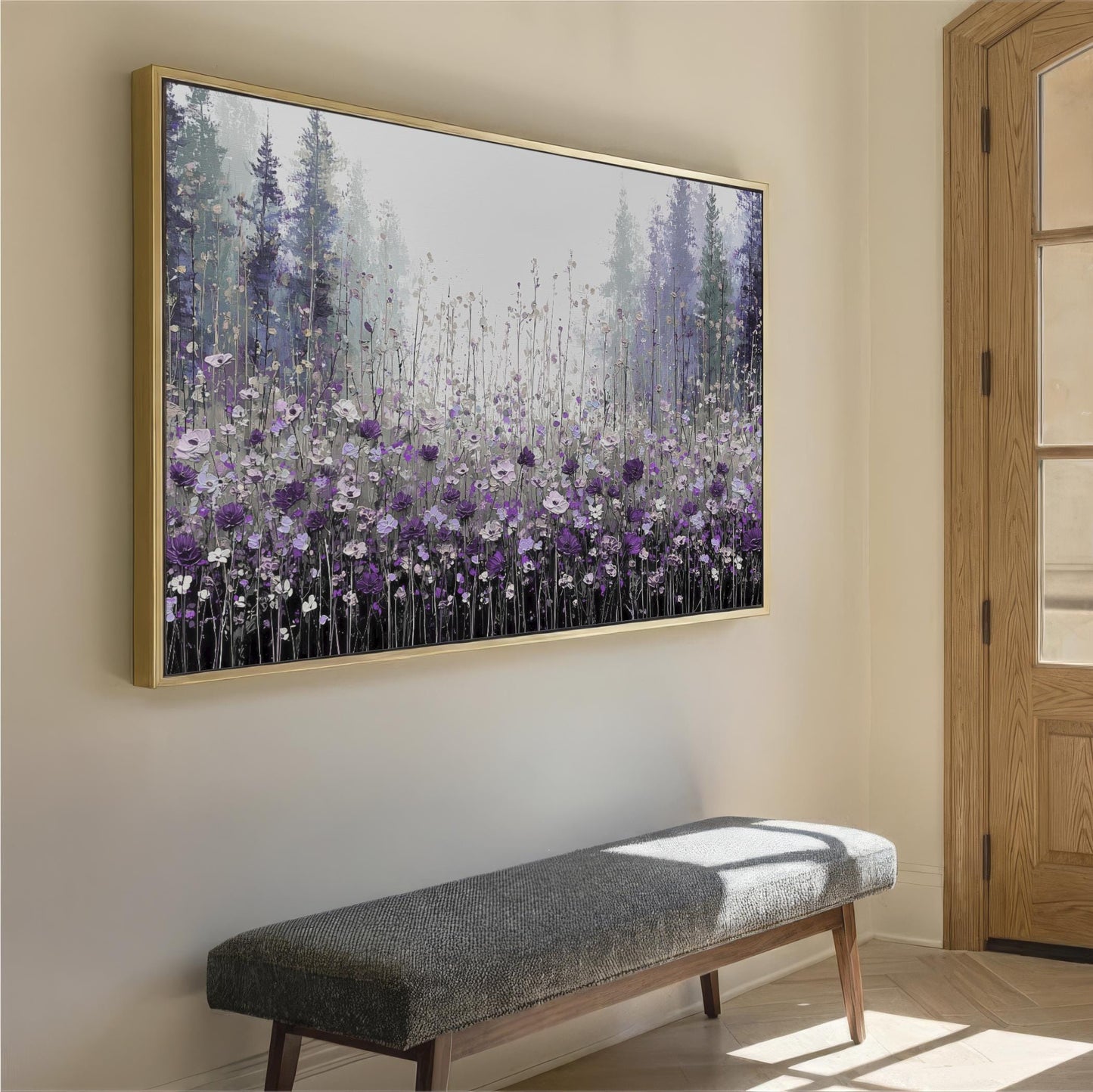 a large framed painting of a field of purple flowers hanging on a wall. Below the painting, there is a gray bench placed against the wall.